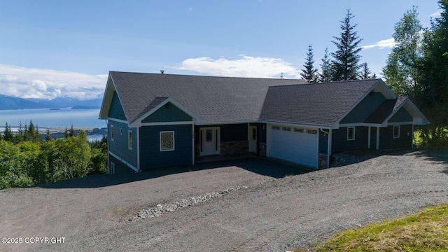 view of front of house featuring a garage, driveway, and a shingled roof