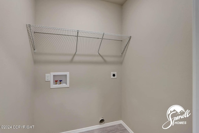 clothes washing area featuring electric dryer hookup, hardwood / wood-style floors, and washer hookup