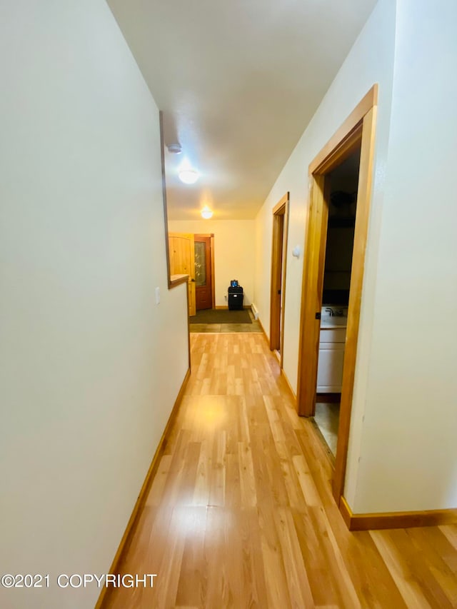 hallway with light hardwood / wood-style floors