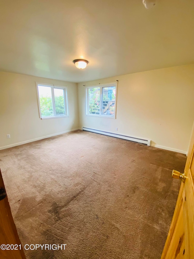 carpeted spare room with baseboard heating