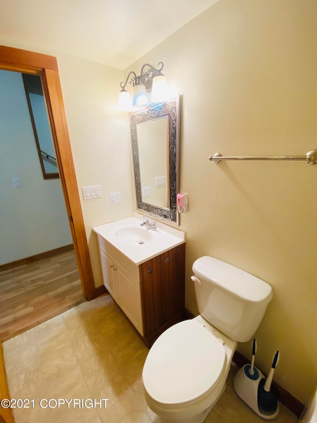 bathroom with oversized vanity, toilet, and wood-type flooring