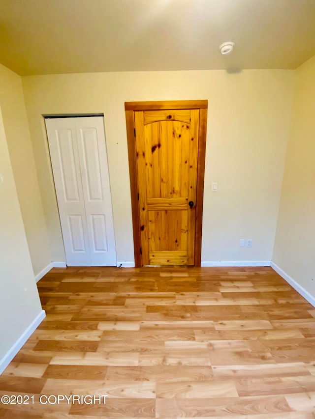 unfurnished bedroom featuring a closet and light hardwood / wood-style flooring