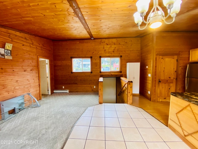 kitchen featuring an inviting chandelier, decorative light fixtures, stainless steel refrigerator, wood walls, and wood ceiling