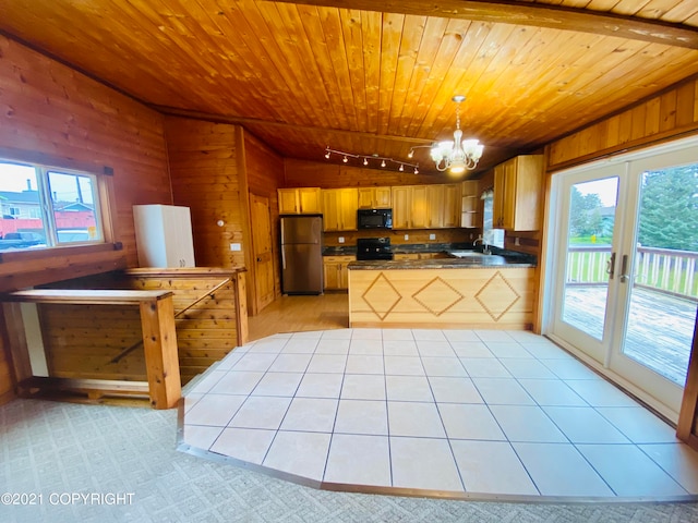 kitchen with stainless steel fridge, wood walls, pendant lighting, sink, and wood ceiling