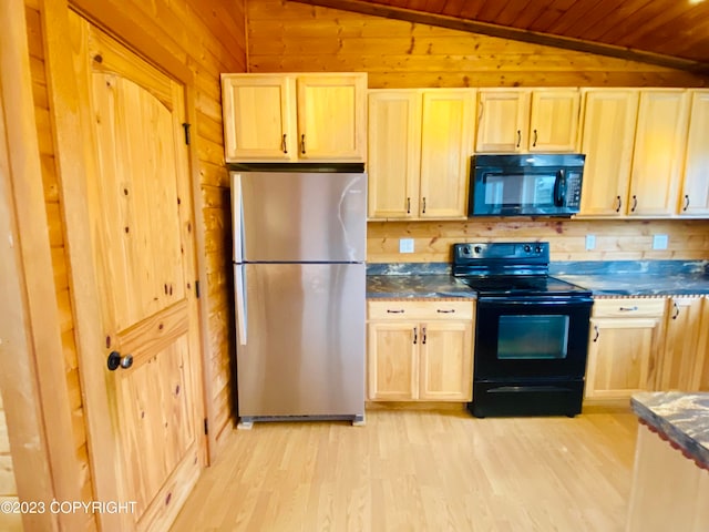 kitchen featuring light hardwood / wood-style floors, black appliances, vaulted ceiling, wooden walls, and light brown cabinetry