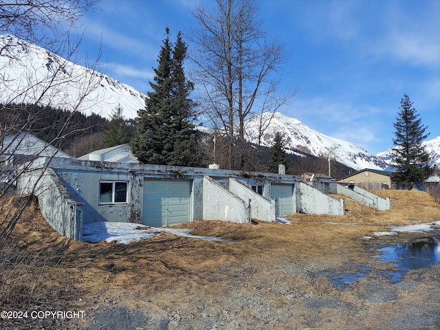 back of property with a mountain view and a garage