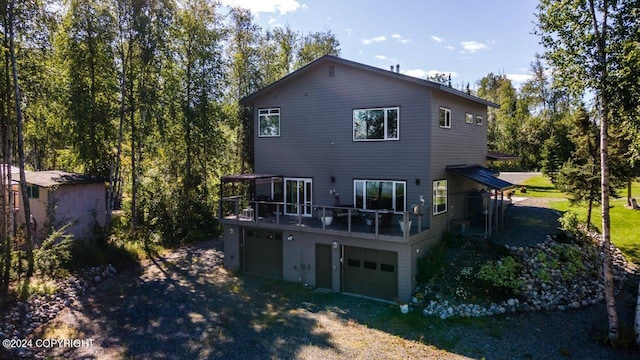 back of property featuring a balcony, a lawn, and a garage