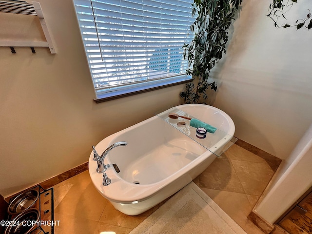 bathroom with a bathing tub and tile floors