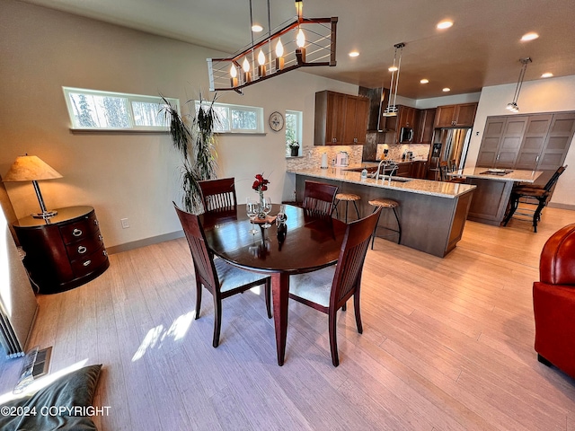 dining room featuring sink and light hardwood / wood-style floors