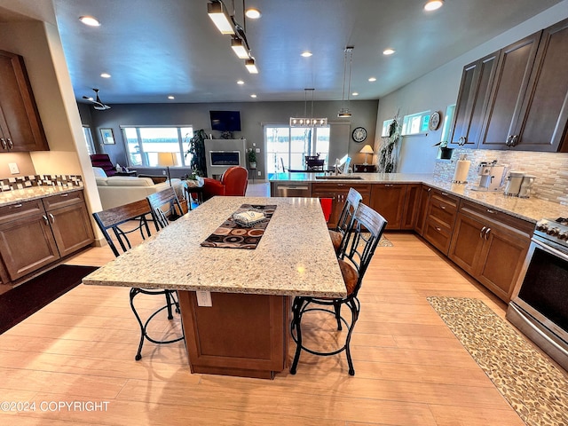 kitchen with light hardwood / wood-style flooring, decorative light fixtures, and a breakfast bar