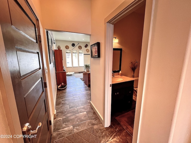 hall featuring sink and dark tile floors