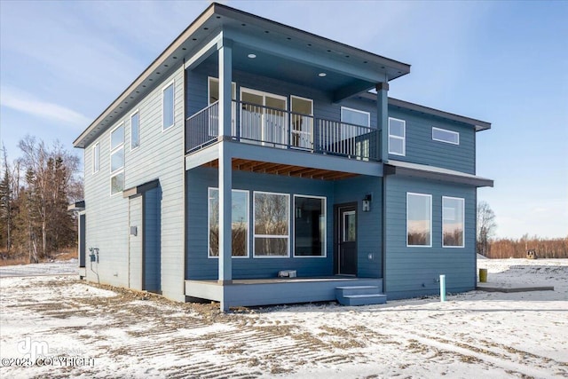 snow covered property featuring a balcony