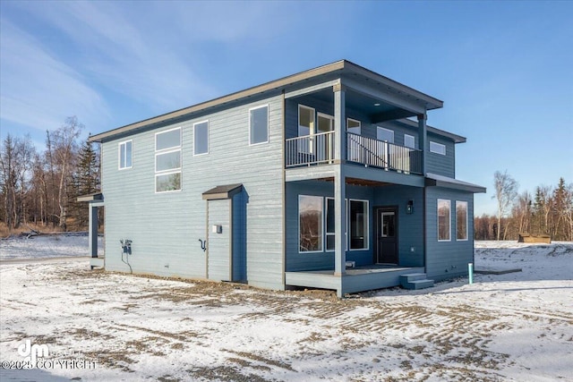 snow covered property featuring a balcony