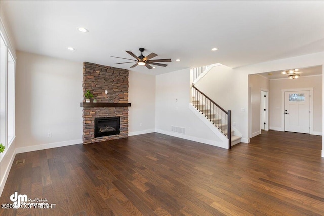 unfurnished living room featuring dark hardwood / wood-style flooring, a fireplace, ceiling fan, and plenty of natural light