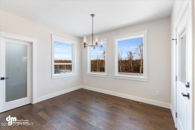 unfurnished dining area featuring dark hardwood / wood-style floors and a notable chandelier