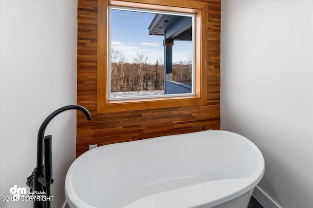 bathroom with wooden walls and a washtub