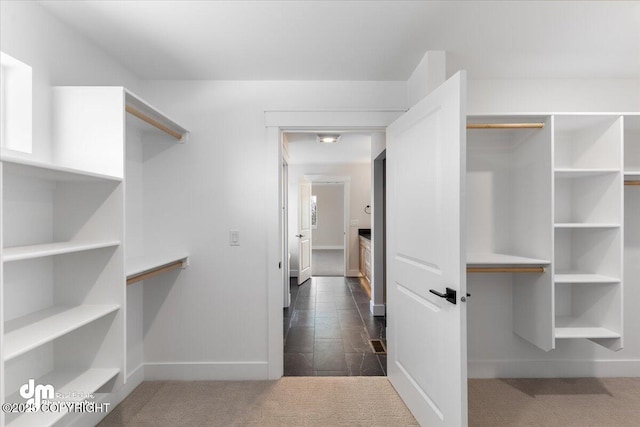 spacious closet featuring dark carpet