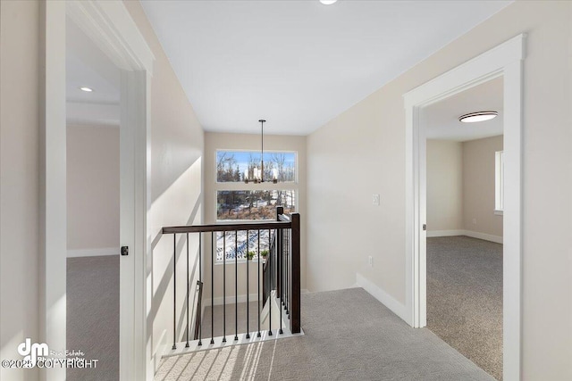 hallway featuring carpet floors and a chandelier