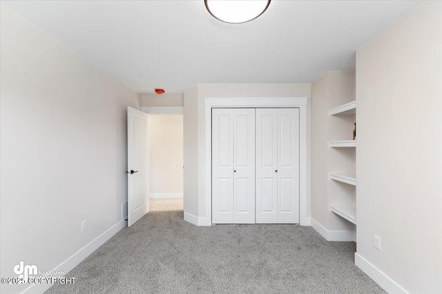 unfurnished bedroom with a closet and light carpet