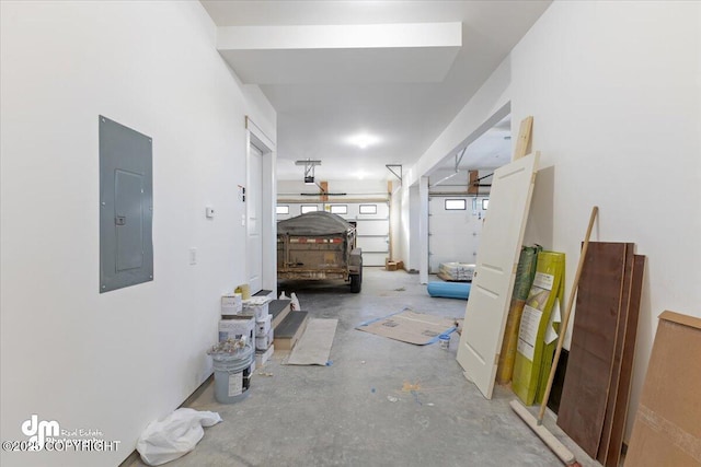 corridor with electric panel and concrete floors