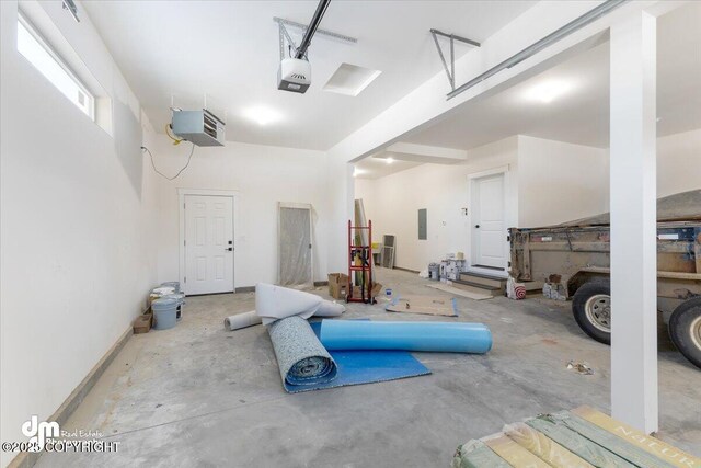 garage with a garage door opener and electric panel