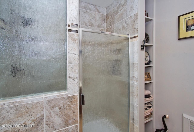 bathroom featuring a shower with door