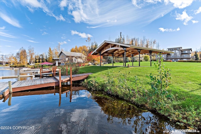 dock area featuring a water view, a lawn, and a gazebo