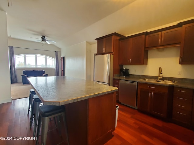 kitchen with stainless steel appliances, a center island, ceiling fan, dark wood-type flooring, and sink