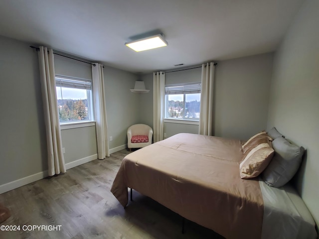 bedroom featuring hardwood / wood-style floors and multiple windows