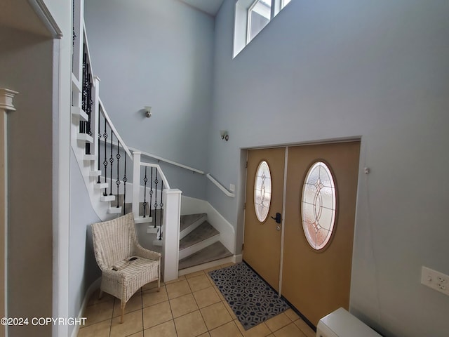 tiled entryway featuring a high ceiling