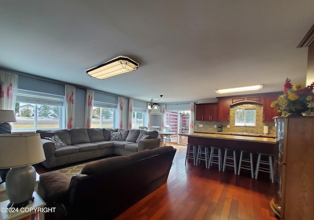 living room with sink, dark hardwood / wood-style flooring, and a notable chandelier