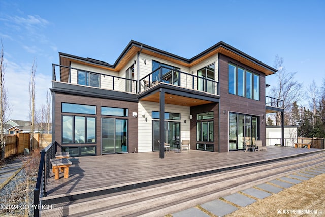 rear view of house with a wooden deck and a balcony