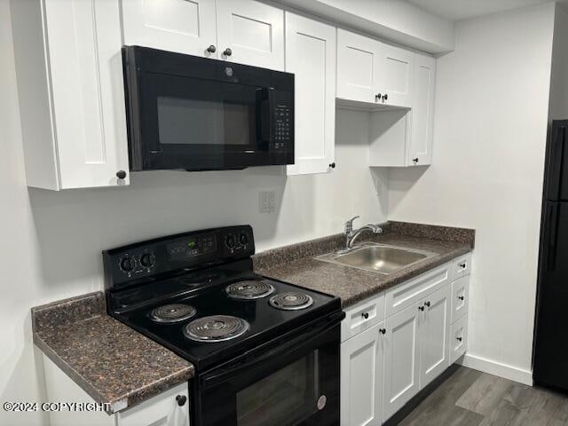 kitchen featuring white cabinets, sink, dark hardwood / wood-style flooring, and black appliances