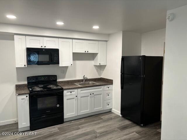 kitchen featuring white cabinets, sink, black appliances, and dark hardwood / wood-style floors