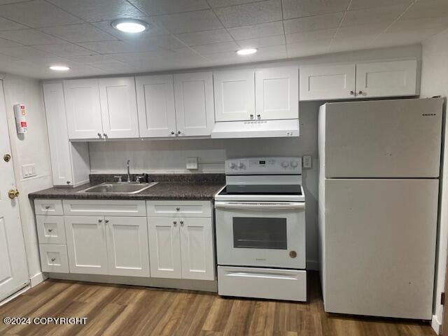 kitchen featuring dark hardwood / wood-style flooring, white appliances, sink, and white cabinets