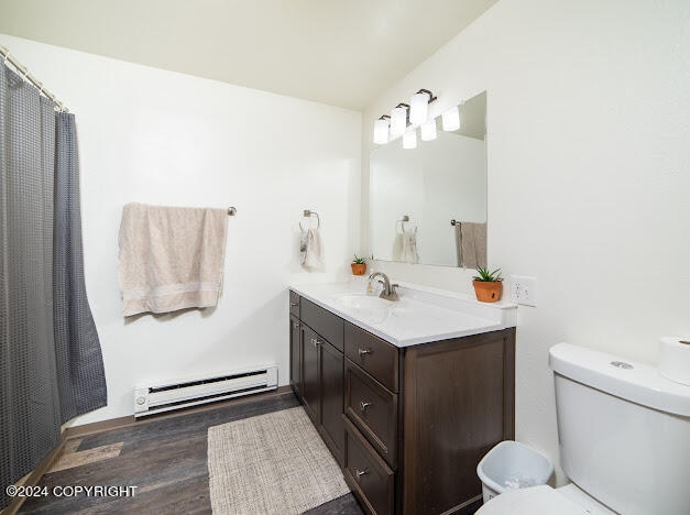 bathroom with a baseboard radiator, vanity, toilet, and hardwood / wood-style flooring