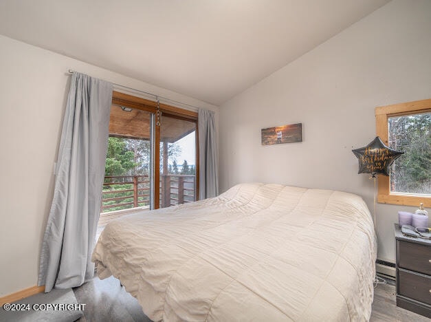 bedroom featuring high vaulted ceiling and baseboard heating