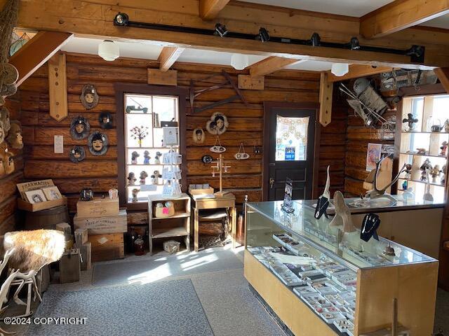 interior space featuring beamed ceiling and rustic walls