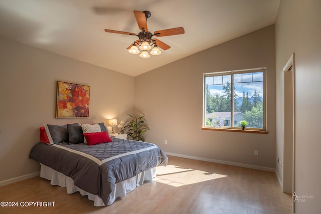 bedroom with light wood-type flooring, vaulted ceiling, and ceiling fan