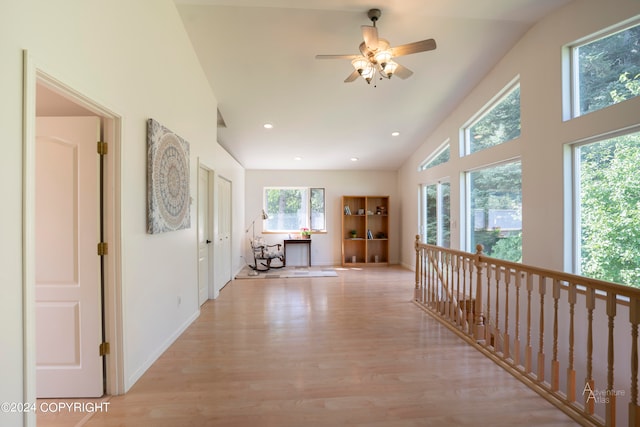 hallway featuring vaulted ceiling and light hardwood / wood-style flooring