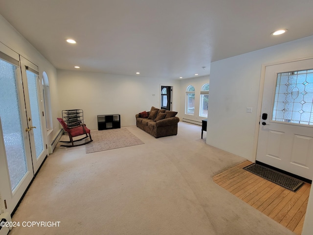 carpeted living room with a baseboard heating unit