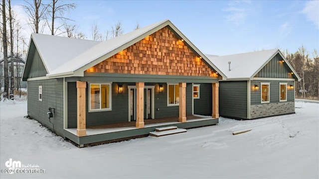 snow covered house with covered porch