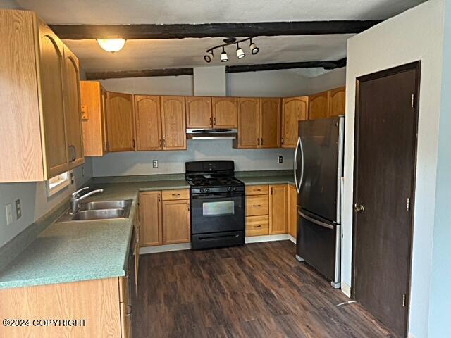 kitchen with black range with gas cooktop, stainless steel refrigerator, beamed ceiling, dark wood-type flooring, and sink