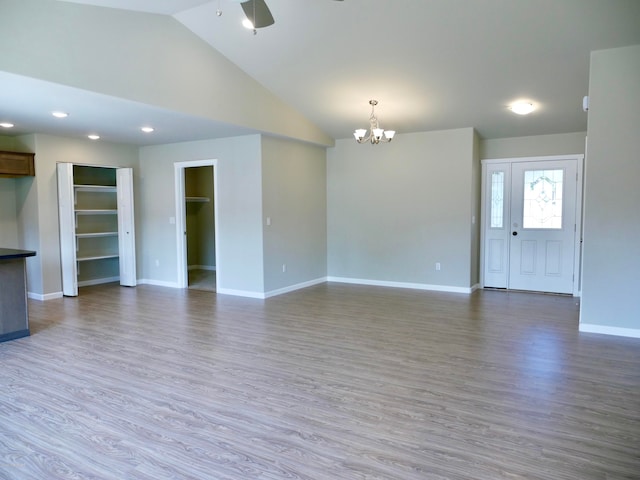 L7 Harman Loop, Wasilla, AK 99654 - unfurnished living room with hardwood / wood-style floors, ceiling fan with notable chandelier, and high vaulted ceiling