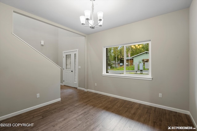 unfurnished room featuring hardwood / wood-style floors and a chandelier