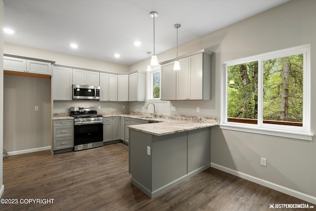 kitchen featuring gray cabinetry, appliances with stainless steel finishes, dark wood-type flooring, and plenty of natural light