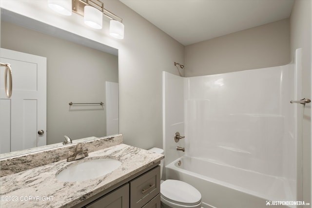 full bathroom featuring washtub / shower combination, vanity, and toilet