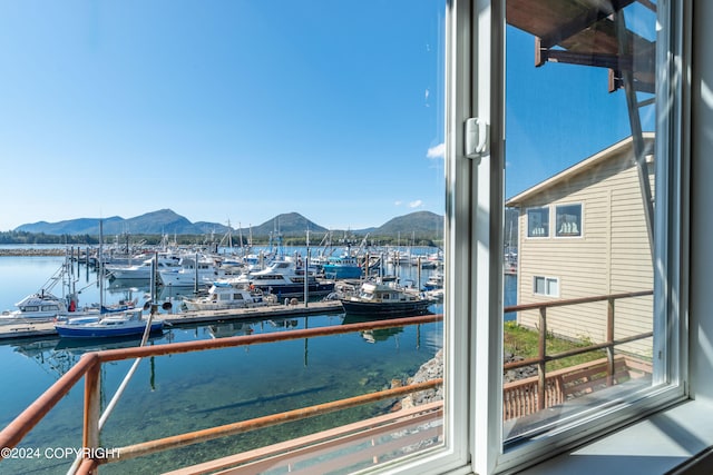 exterior space with a boat dock and a water and mountain view