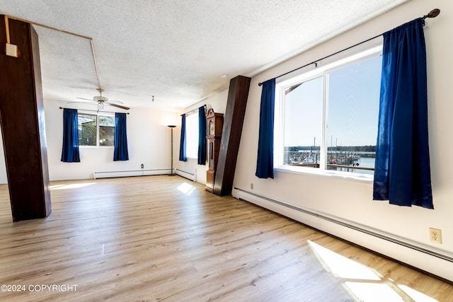 spare room featuring a textured ceiling, ceiling fan, hardwood / wood-style floors, and a baseboard radiator