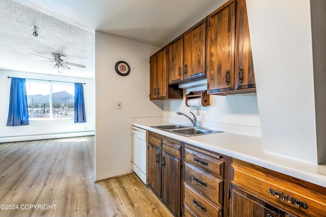 kitchen with a mountain view, light hardwood / wood-style flooring, sink, dishwasher, and ceiling fan